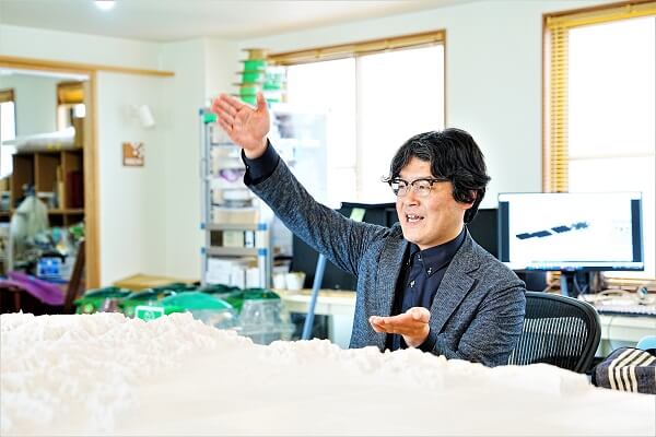 田中先生が手を広げ大型3Dプリントについて語る