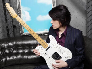 TAKUYA氏が凸凹したデザインの白いギターを手にしている